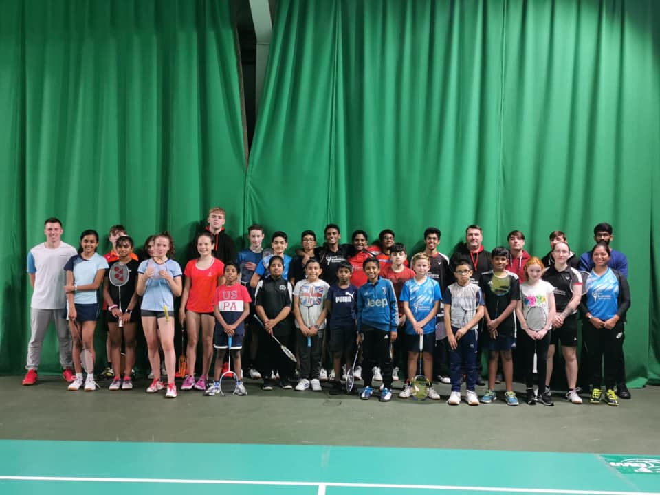 Rayappan Badminton Academy players and coaches posing together on court